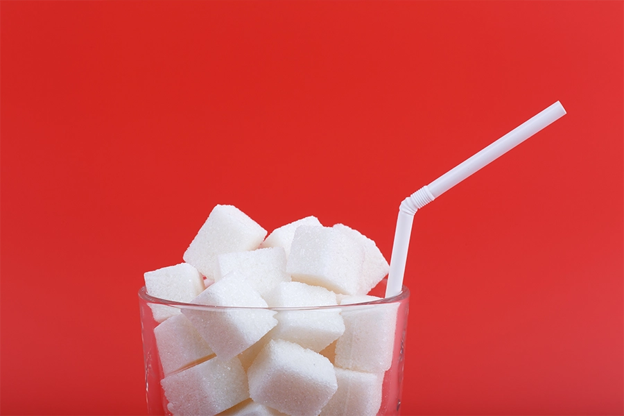 Glass with straw full of sugar cubes